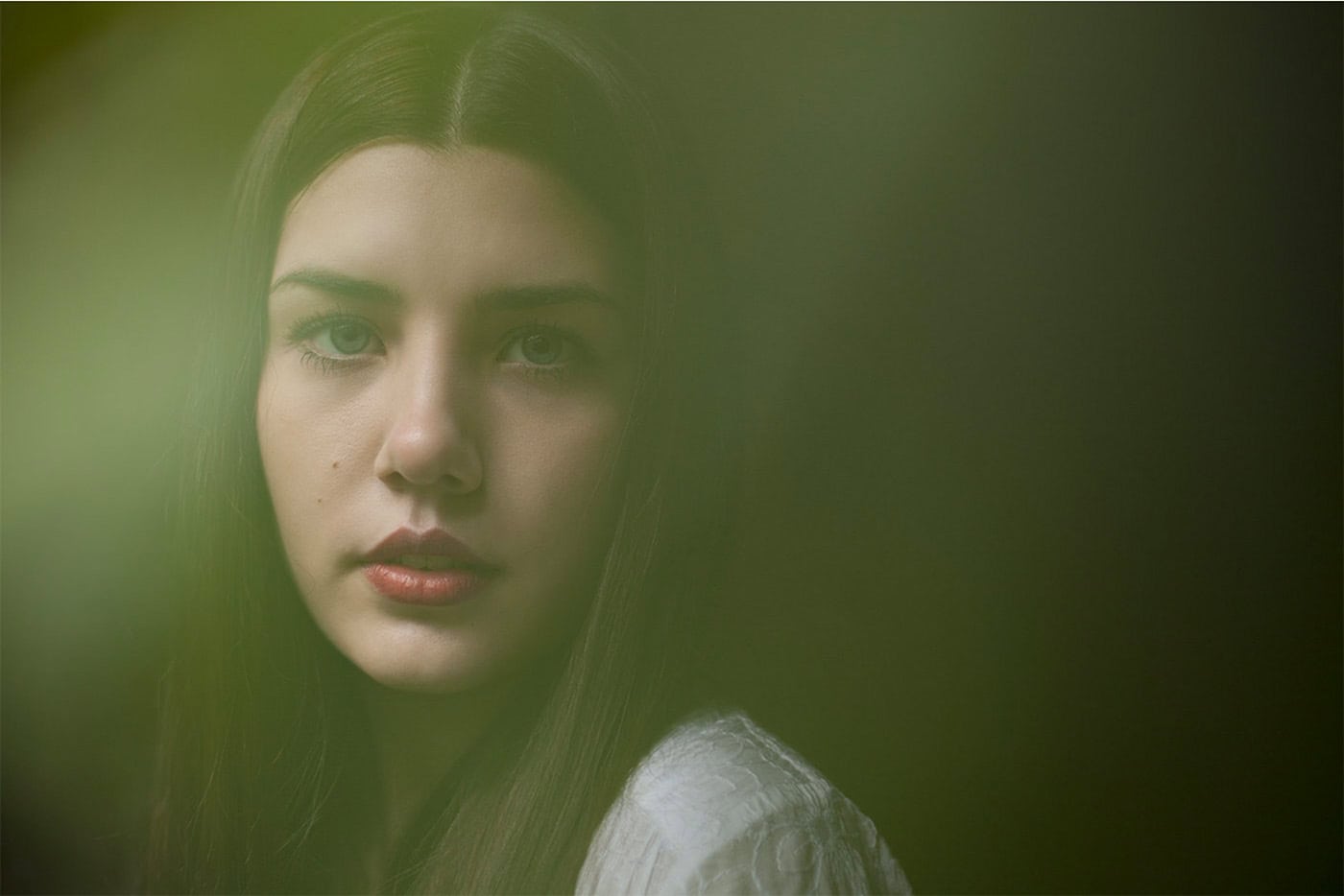 Porträt einer jungen Frau mit dunklen Haaren und natürlichem Licht.