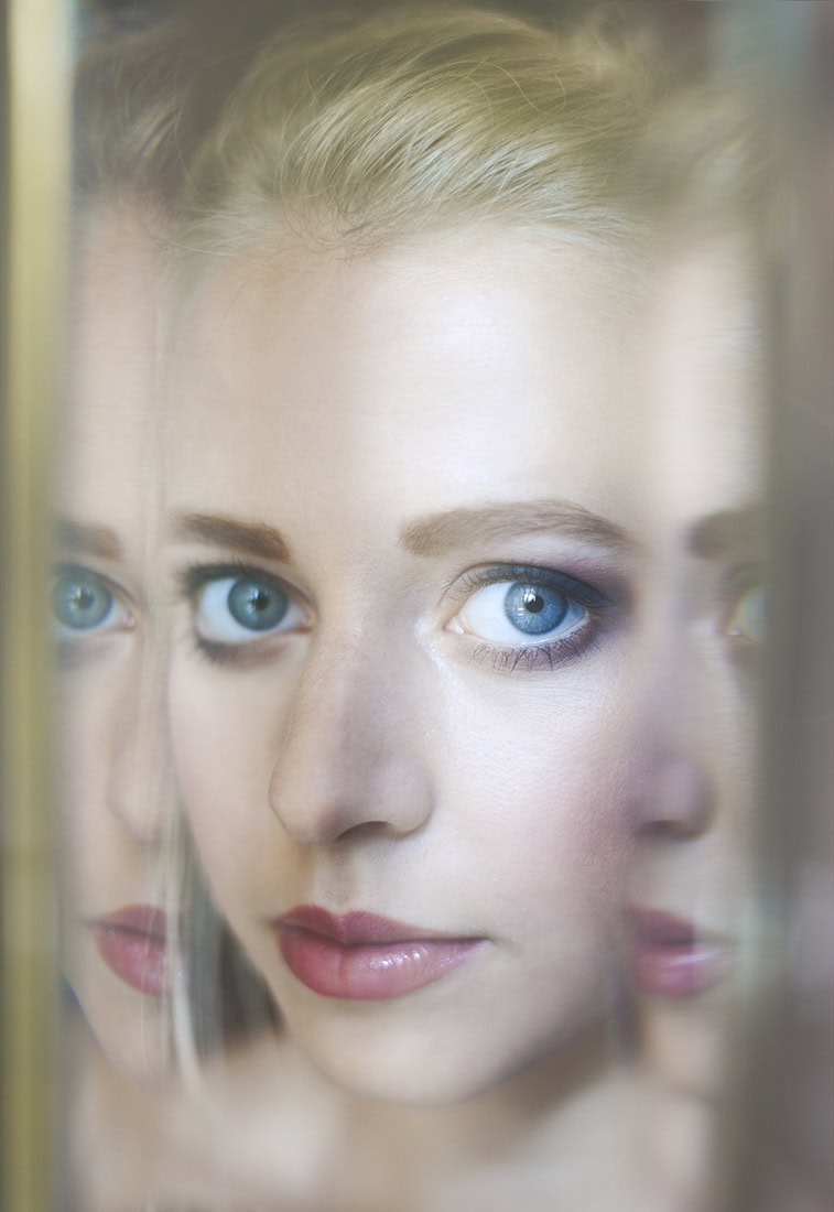 Porträt einer jungen Frau mit blauen Augen, kreative Fotografie, professionelle Portraitaufnahme.