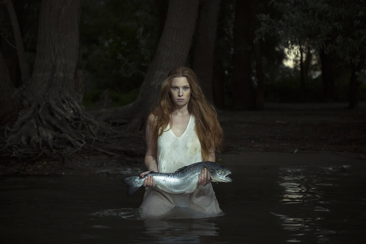 Frau hält Fisch im Wasser, Naturaufnahme in Köln, professionelle Fotografie.