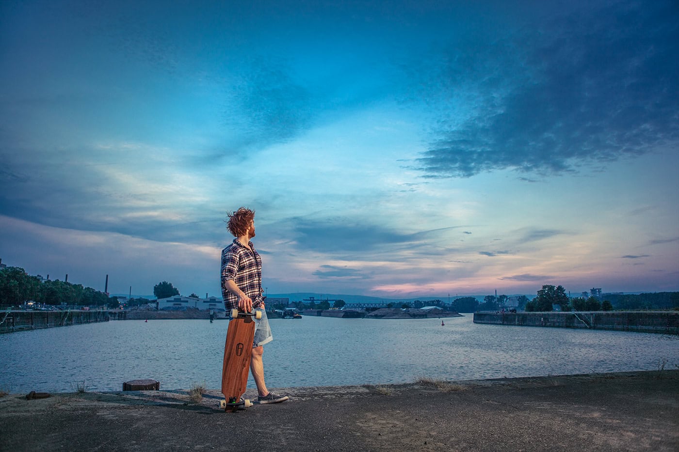 Frau mit Koffer am Rhein bei Sonnenuntergang in Köln, professionelle Reisefotografie.