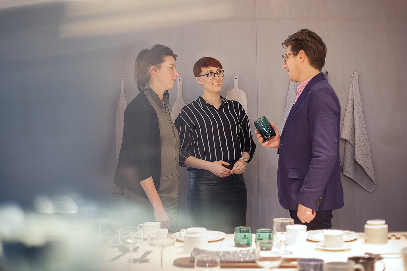 Geschäftliches Treffen mit drei Personen in modernem Büro, professionelle Atmosphäre.