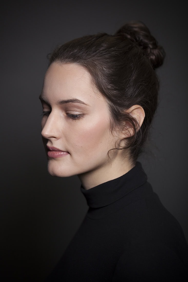 Elegantes Porträt einer jungen Frau mit dunklem Turtleneck, professionell fotografiert.