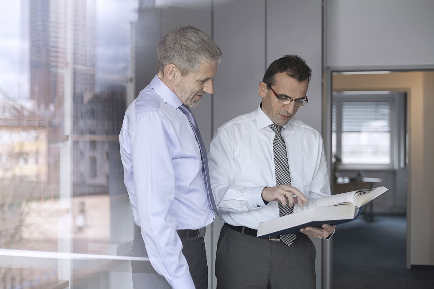 Zwei Geschäftsleute im Büro bei der Besprechung, professionelle Business-Fotografie.