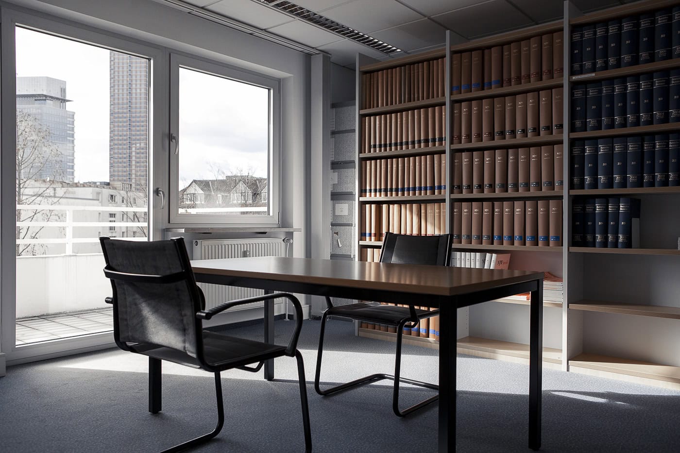 Modernes Büro mit Schreibtisch, Stühlen und Bücherregal in Köln.