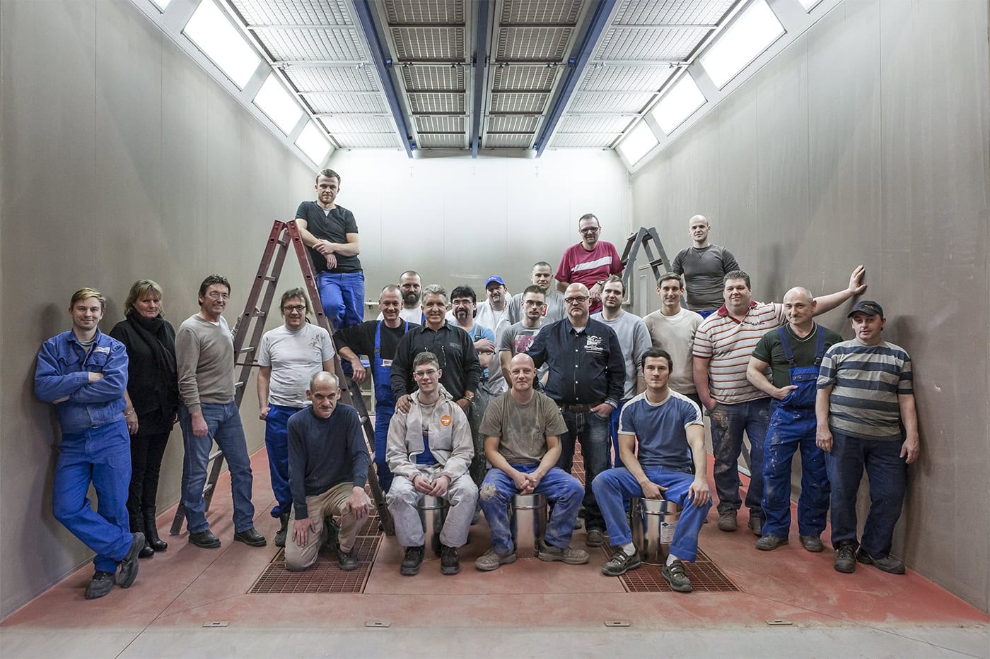 Teamfoto in Werkstatt mit 20 Personen, professionelle Arbeitsumgebung.