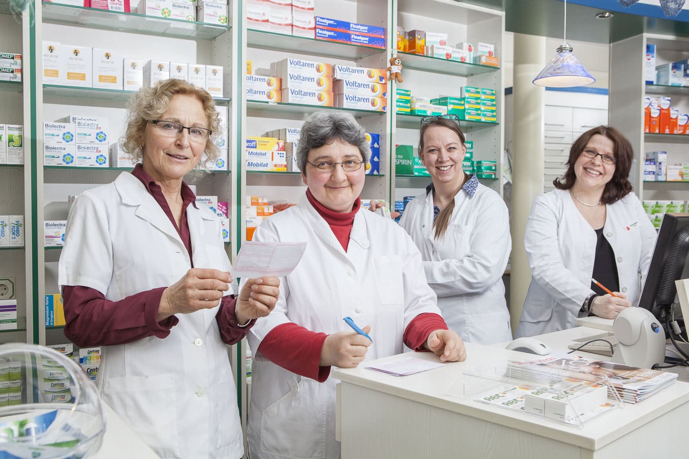 Frauen in weißen Laborkitteln arbeiten in einer Apotheke in Köln.