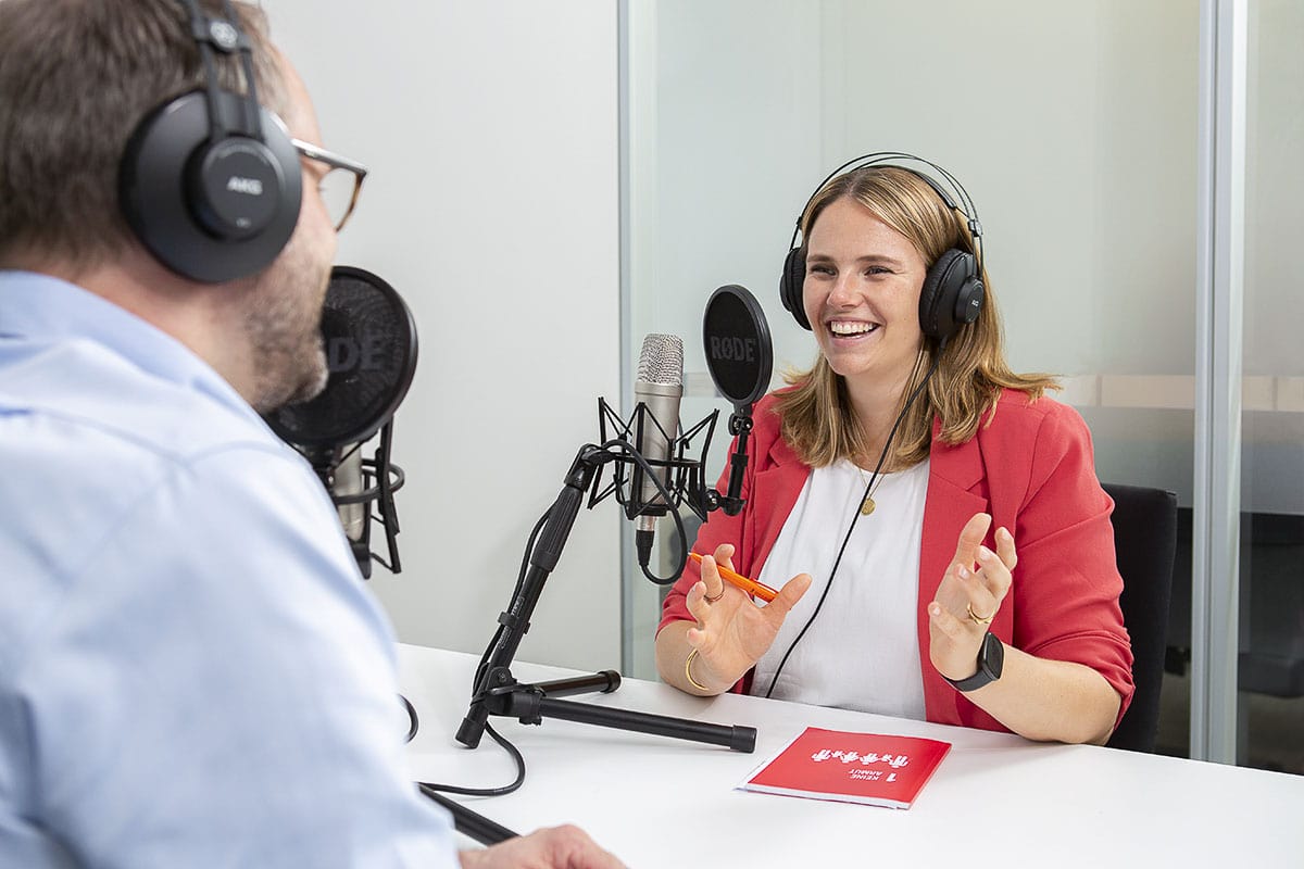Frau im Gespräch während eines Podcasts in einem Tonstudio, professionell fotografiert.