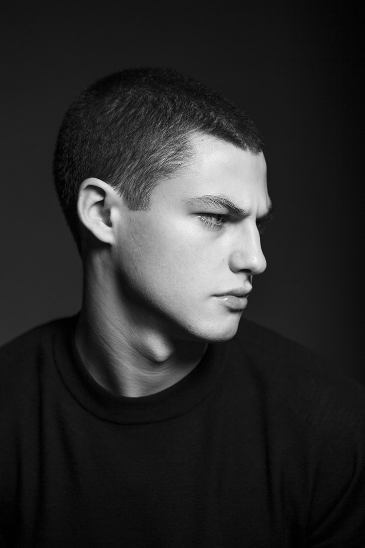 Porträt eines jungen Mannes in Schwarz-Weiß, professionelle Fotografie.