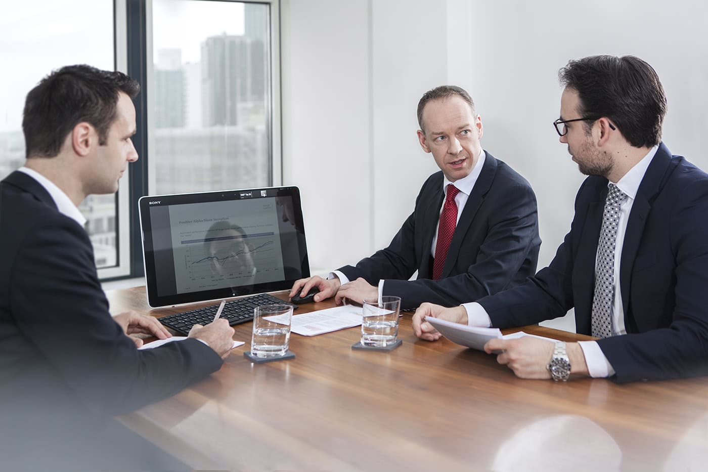 Drei Männer im Business-Meeting bei einer Besprechung im modernen Büro.