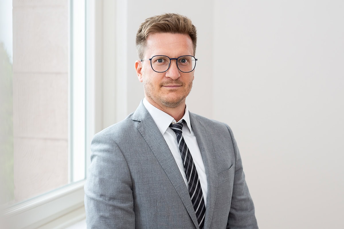Professionelles Portrait eines Mannes in Anzug mit Brille in Köln.