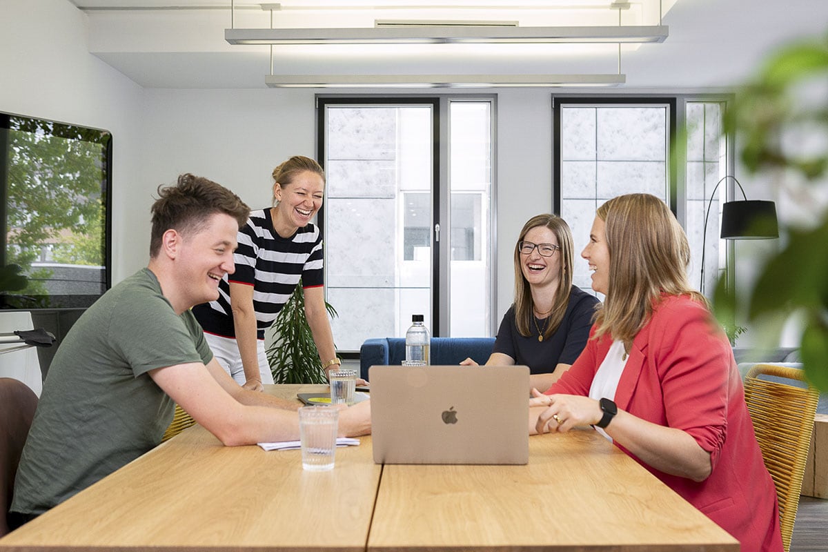 Vier Personen eines Startups bei einem Businessmeeting im modernen Konferenzraum