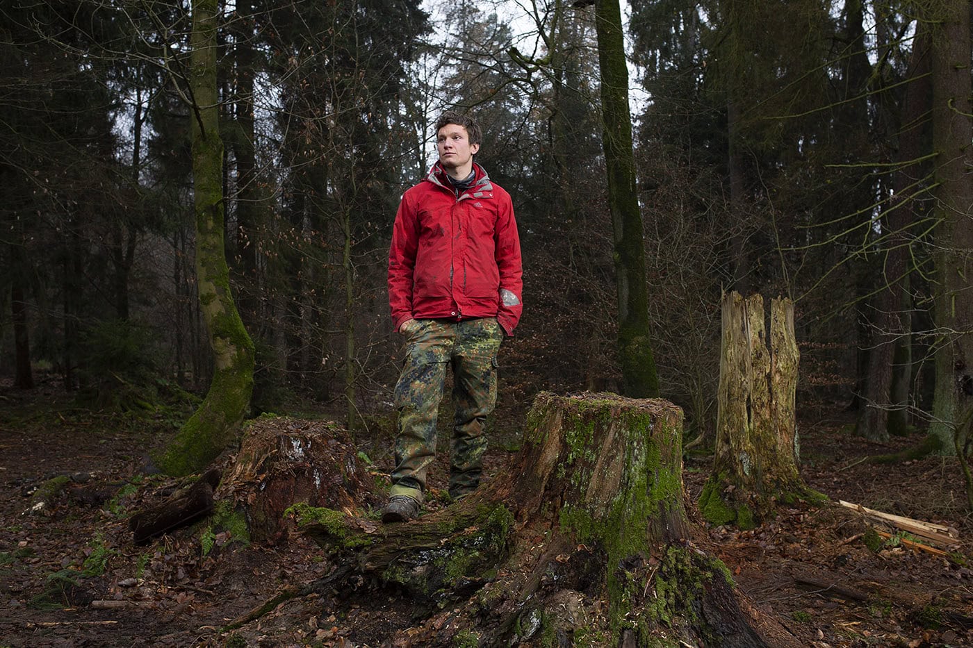 Mann in roter Jacke im Wald bei Natur- und Landschaftsfotografie in Köln.