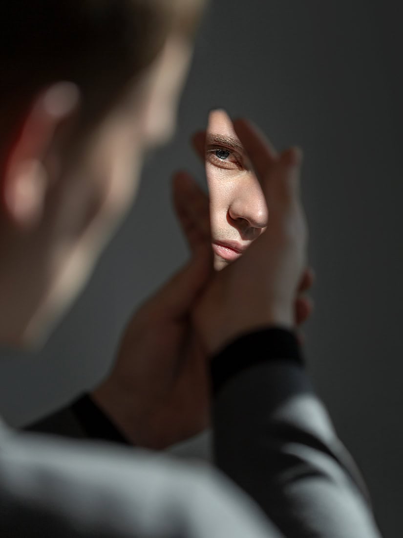 Nahaufnahme eines Gesichts mit Sonnenlicht, Fokus auf die Augen, künstlerische Fotografie.