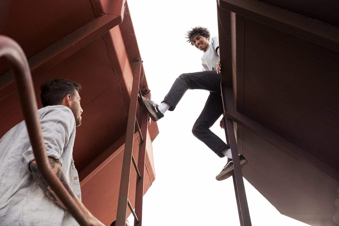 Zwei junge Menschen auf einer Treppe zwischen Gebäuden, kreative Perspektive.