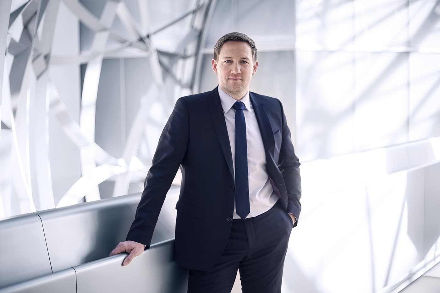 Professionelles Businessporträt eines Mannes in Anzug im modernen Gebäude in Köln.
