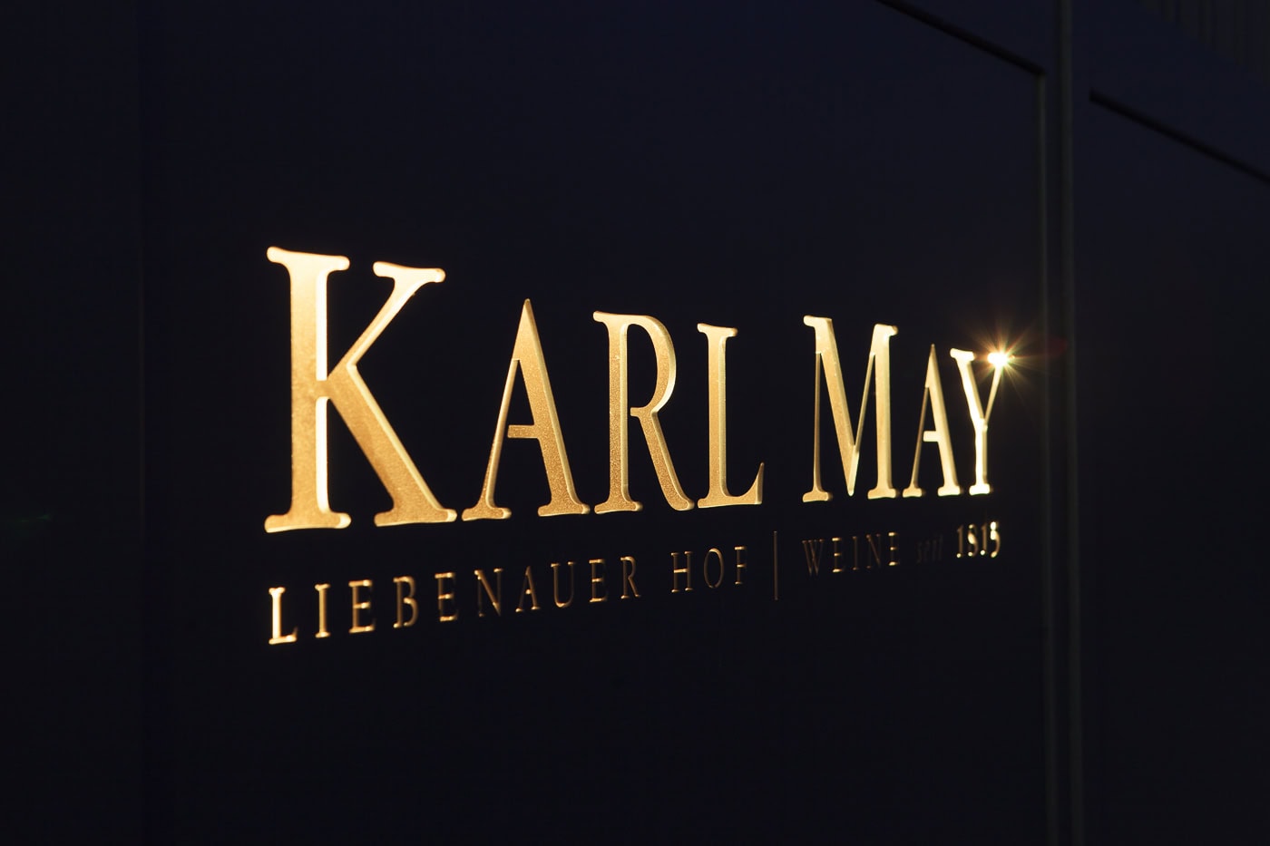 Beleuchtetes Schild mit "Karl May" Schriftzug und "Liebenaur Hof" in Köln.