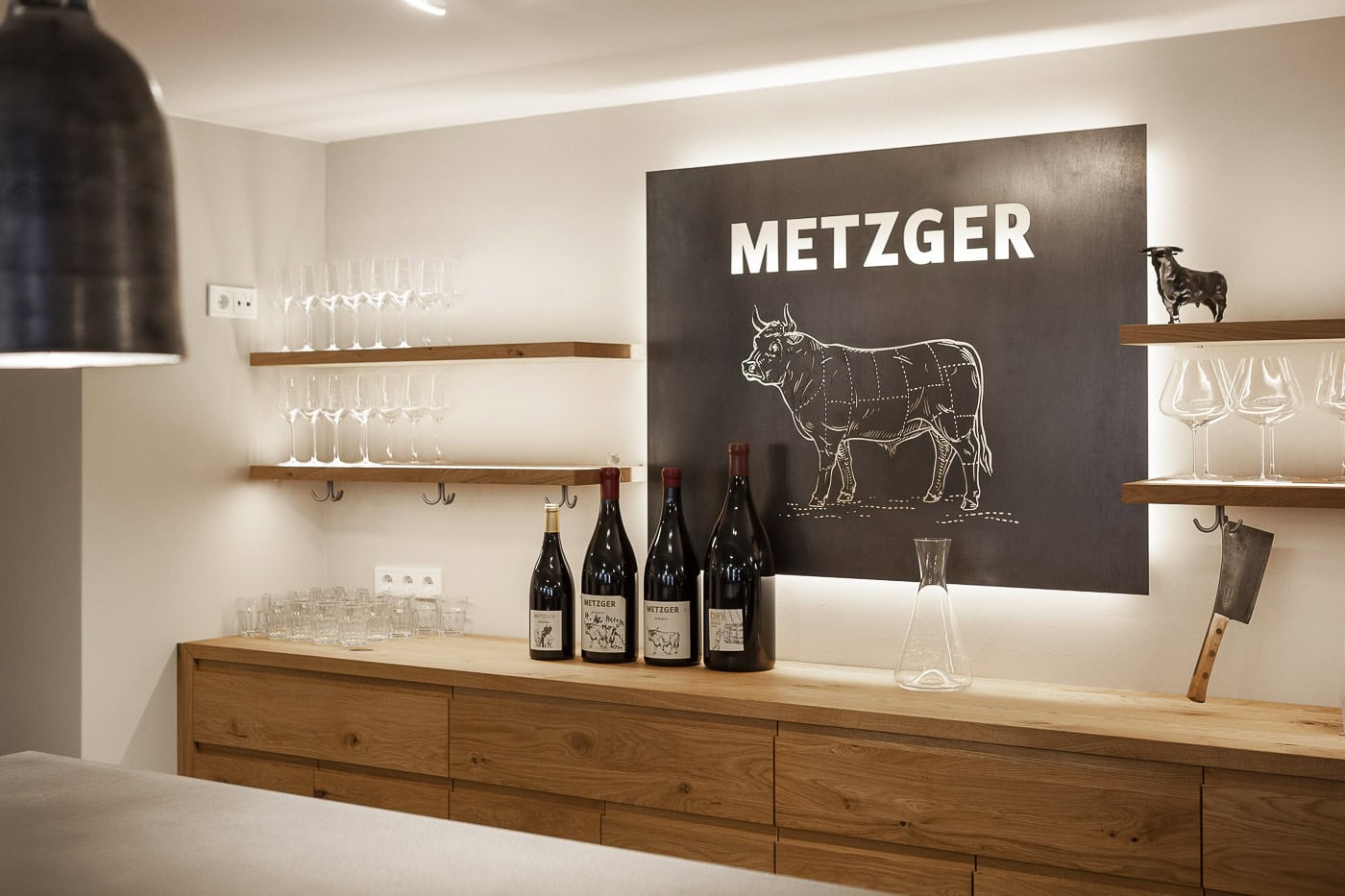 Moderne Küche mit Metzger-Schildern, Weinflaschen und Gläsern.