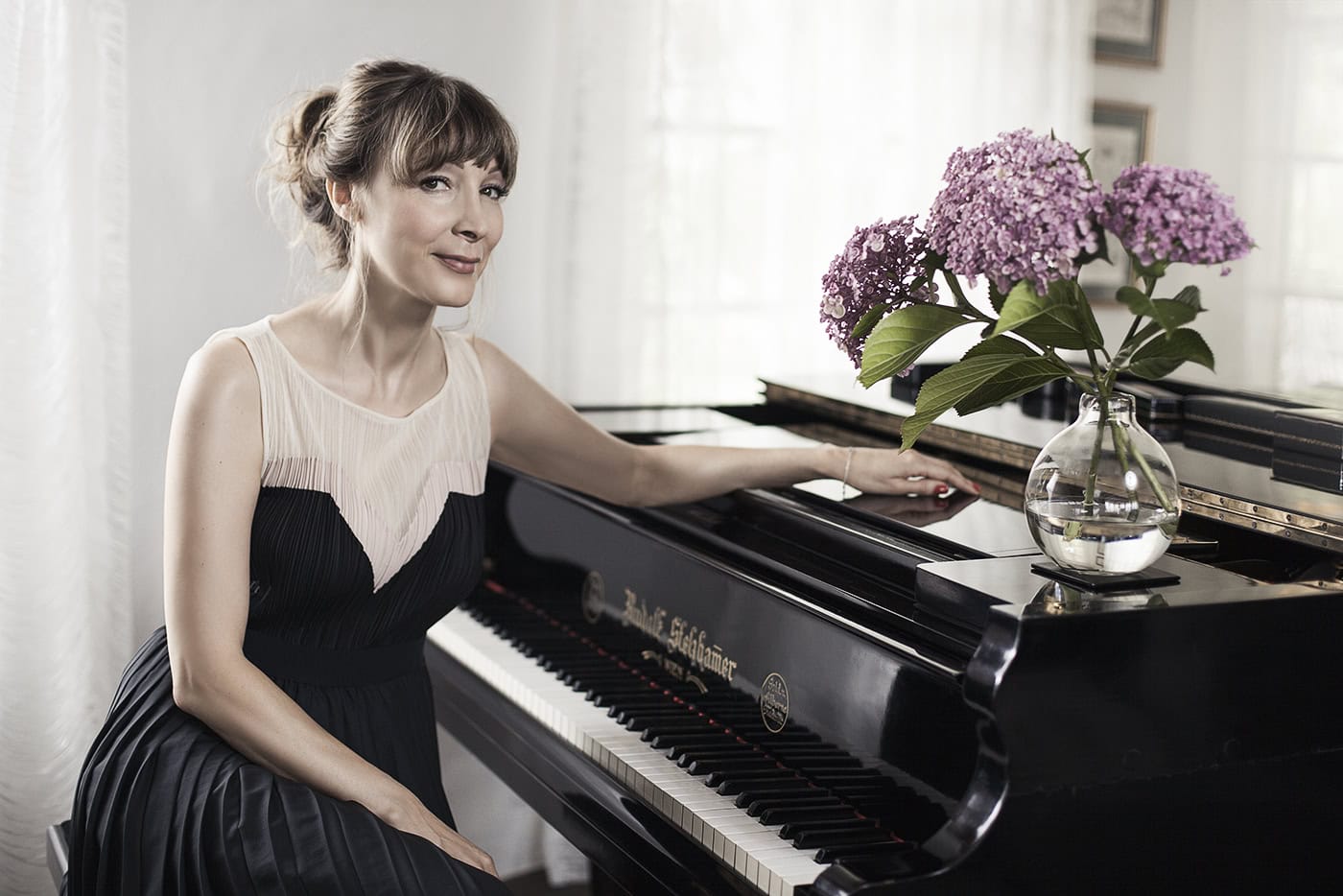 Frau spielt Klavier mit Blumen im Wohnzimmer, professionelle Musikfotografie.