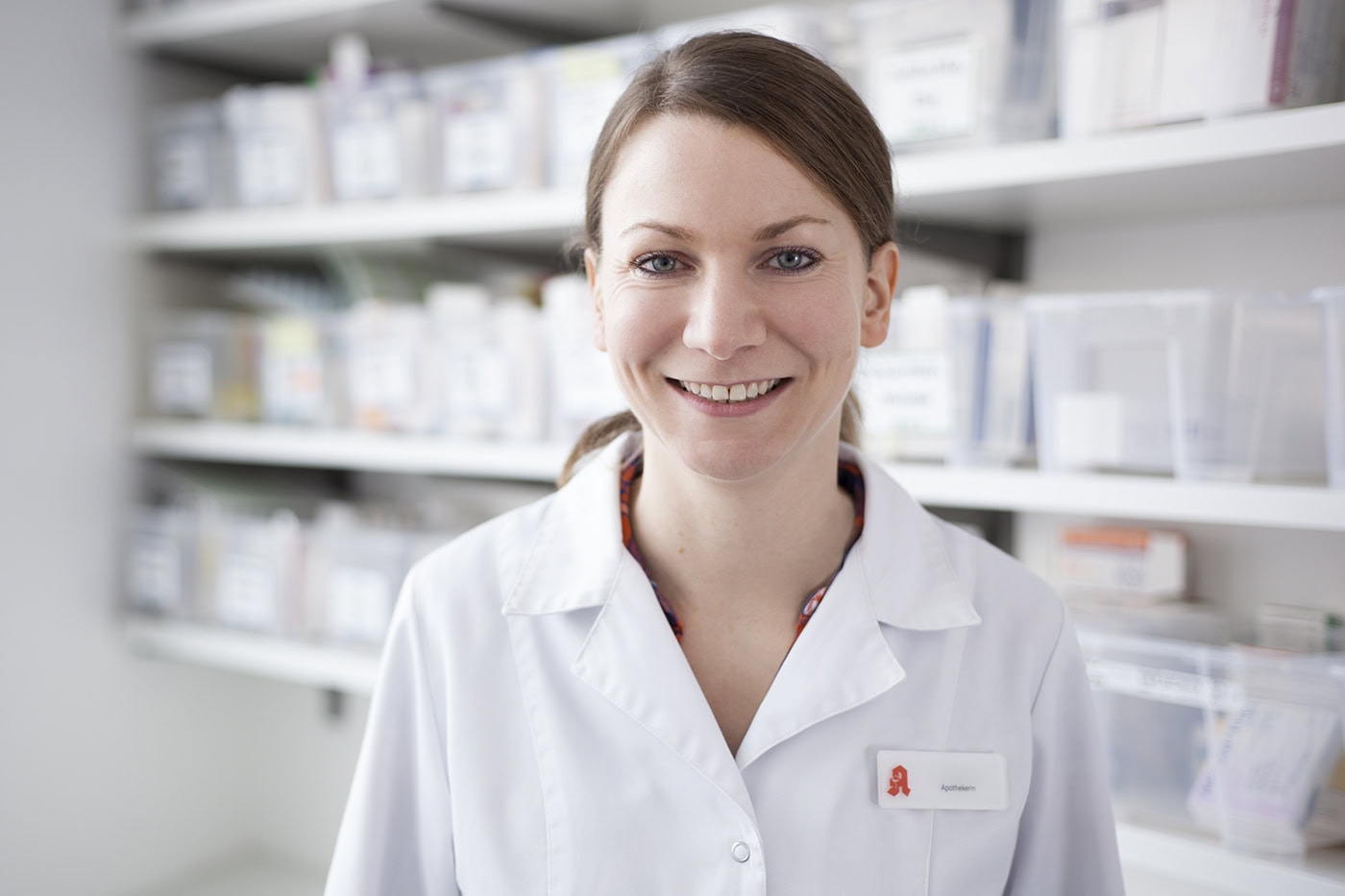 Freundliche Apothekerin in Köln bei der Arbeit in der Apotheke.