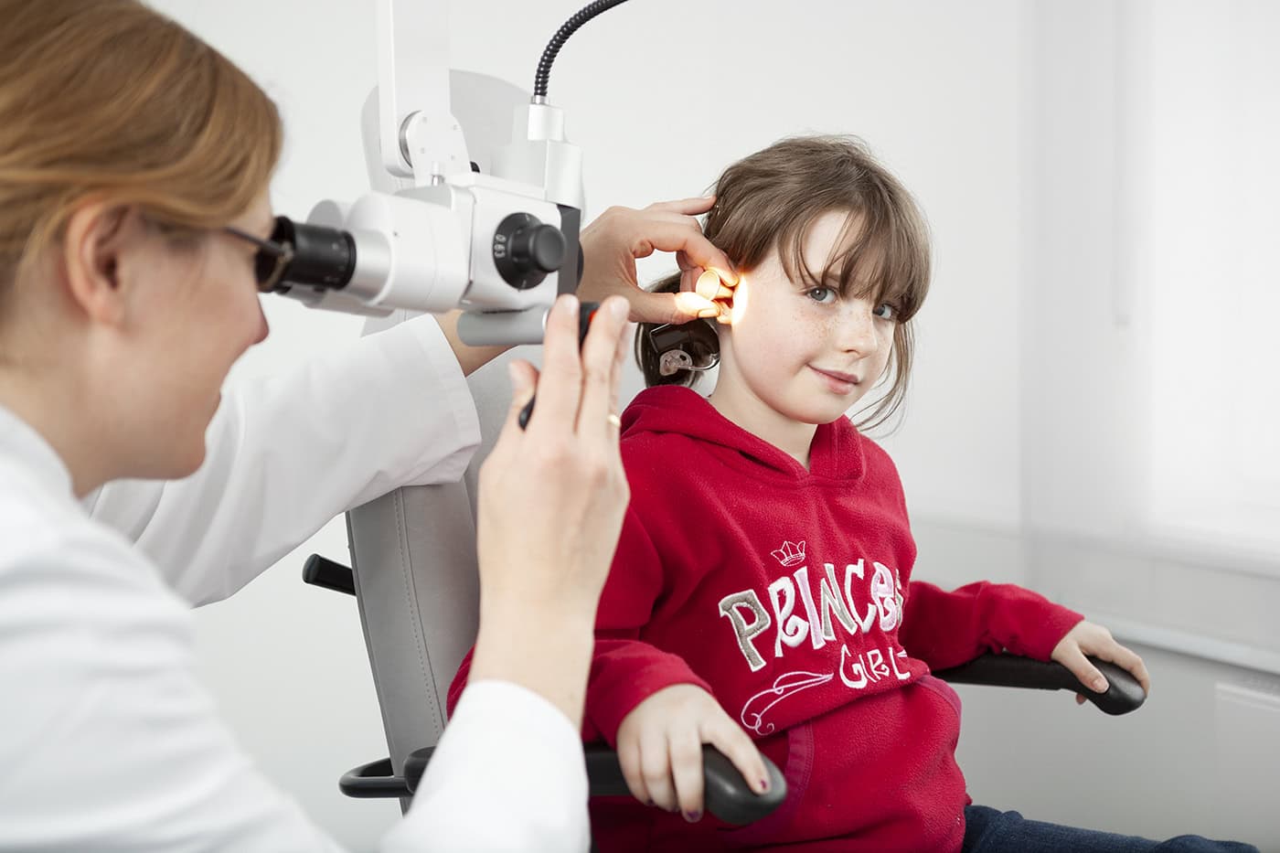 Kinderarzt führt Hörtest bei einem Mädchen in einer Klinik in Köln durch.