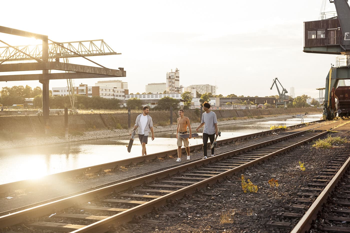 Drei junge Menschen am Rhein bei Sonnenuntergang, urbane Fotografie, Köln.