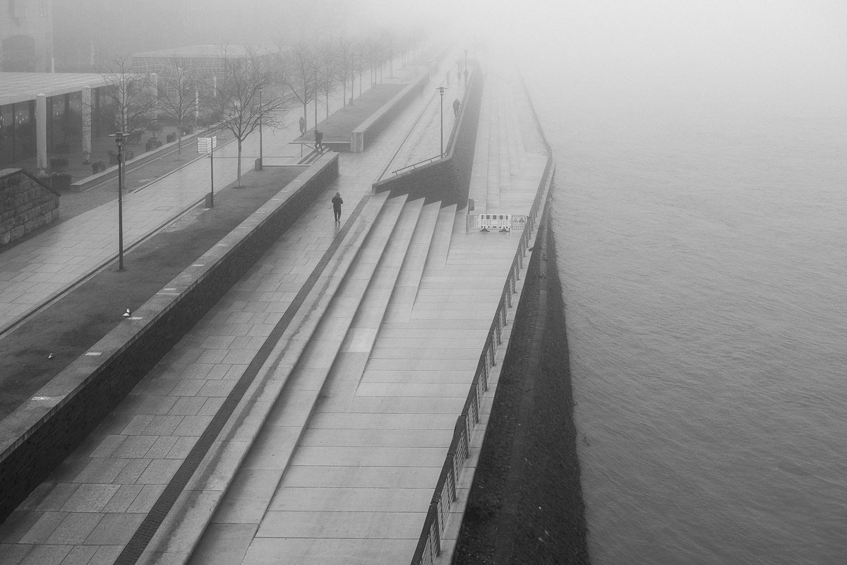 Moderne Treppen am Rheinufer in Köln bei Nebel, Stadtansicht.