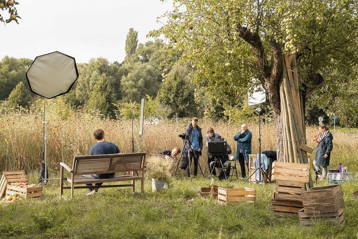 Fotografisches Bild eines Filmsets im Freien mit Crew und Ausrüstung.