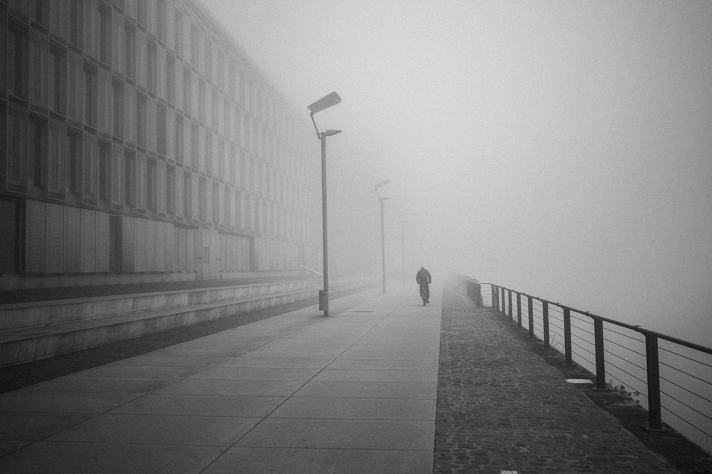 Nebeliger Spaziergang am Ufer mit Person in Köln, Michael Zellmer Fotografie.