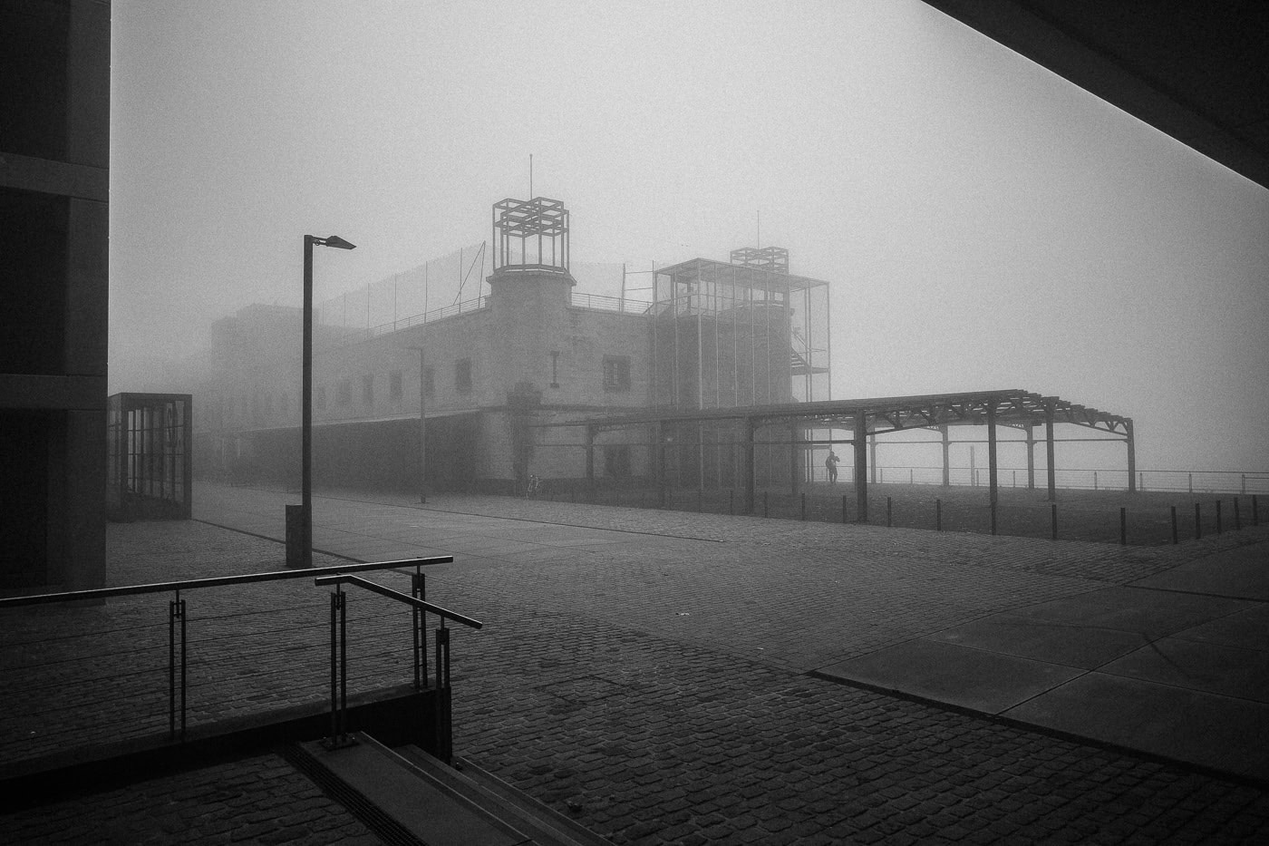 Nebelverhülltes Hafenbecken in Köln, atmosphärische Schwarz-Weiß-Fotografie.