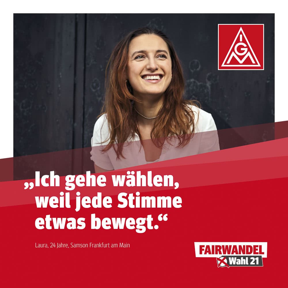 Fröhliche junge Frau bei Wahlkampfveranstaltung in Köln, Wahlplakat im Hintergrund.