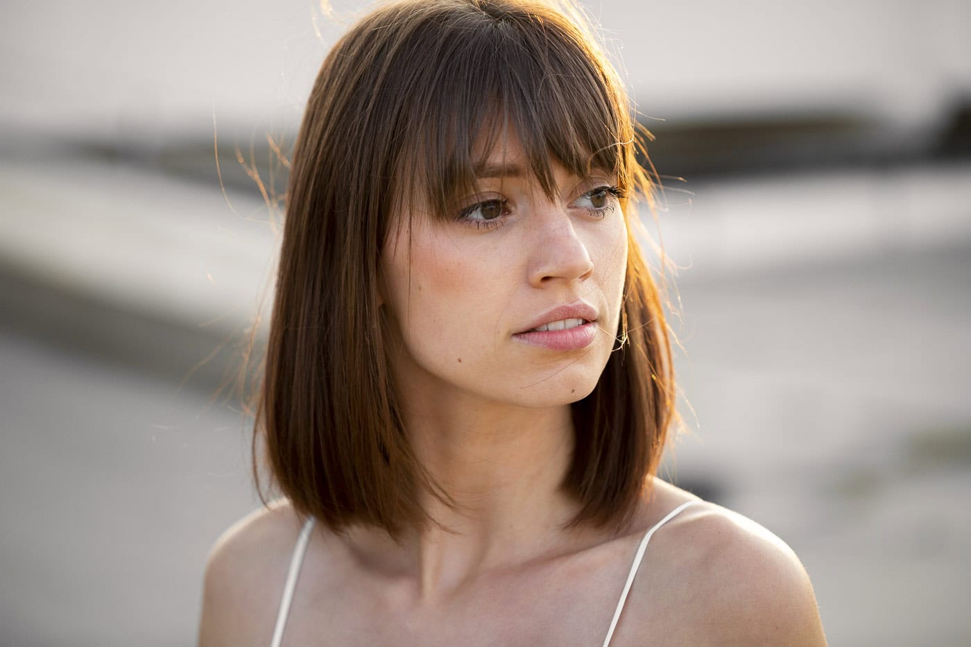 Porträt einer jungen Frau mit braunen Haaren und natürlichem Make-up am Wasser, Sonnenlicht, profess.