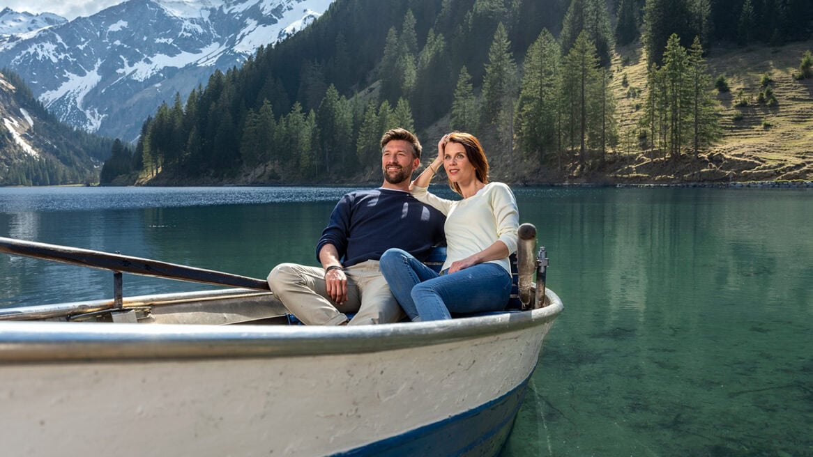 Alpensee mit Paar im Boot, Natur, Berge, Wasser, Landschaft, Fotografie.