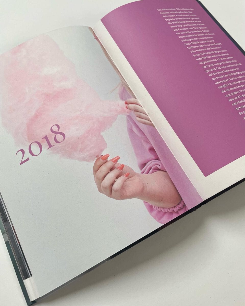 Offene Zeitschrift mit pinkem Hintergrund und "2018" auf der linken Seite.