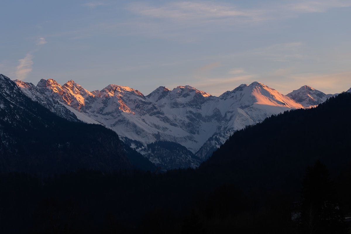 Atemberaubende Berglandschaft mit schneebedeckten Gipfeln bei Sonnenuntergang.