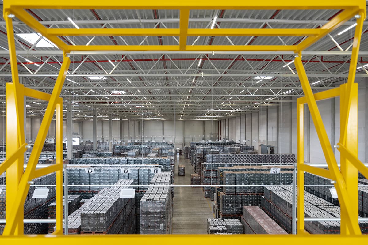 Riesige Lagerhalle eines Logistikunternehmens, von oben, knapp unter dem Hallendach fotografiert.