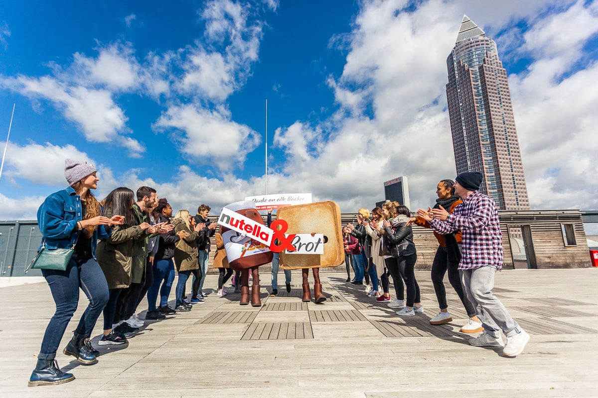 Gruppe von Menschen, die Nutella & Brot in der Stadt fotografieren.
