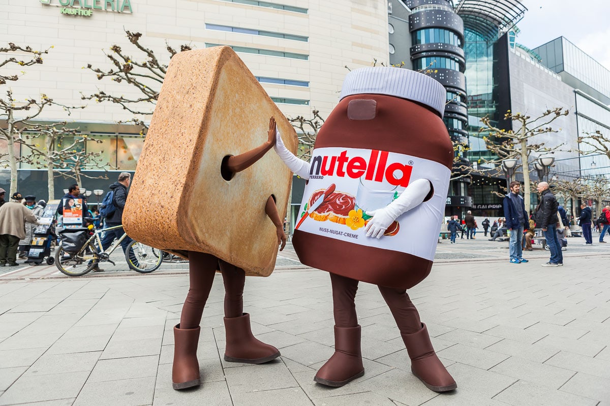 Lustiges Nutella-Maskottchen und Keks-Charakter in Köln, Stadtbild, Menschen.