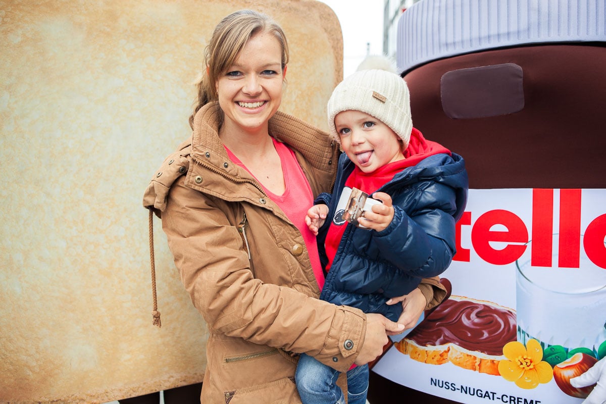 Kinder und Mutter beim Naschen von Nutella.
