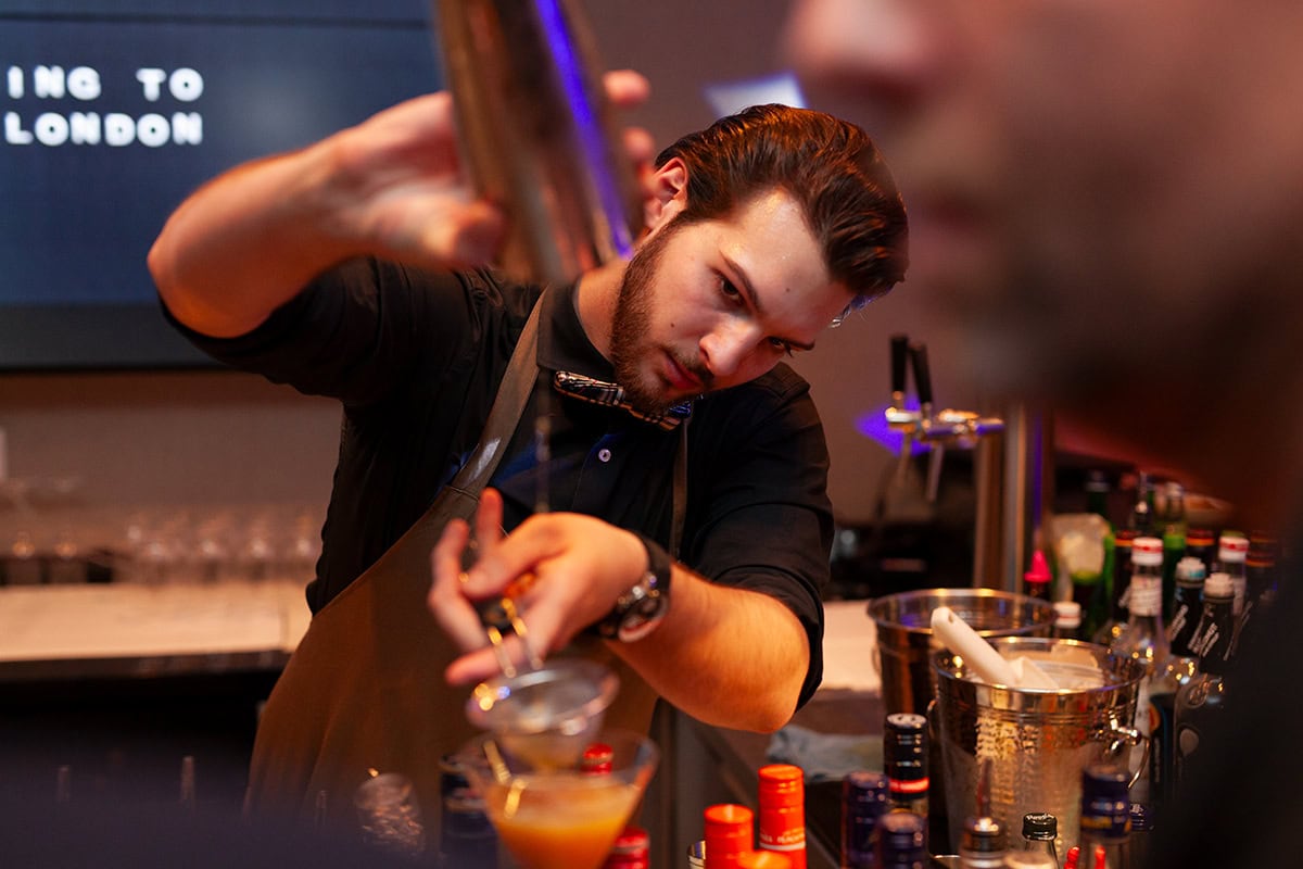 Mann mixt kreative Cocktails in einer Bar in Köln.
