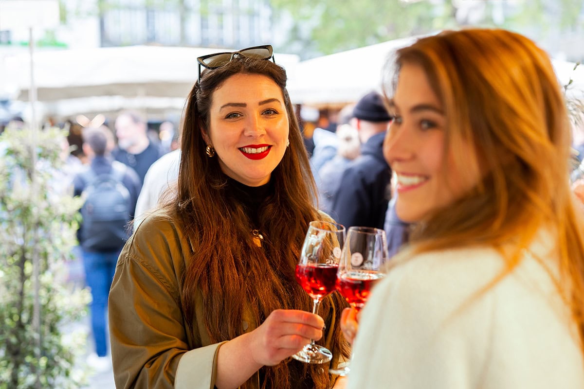 Zwei Frauen beim Blumenfest in Köln, genießen Wein und gute Gesellschaft.