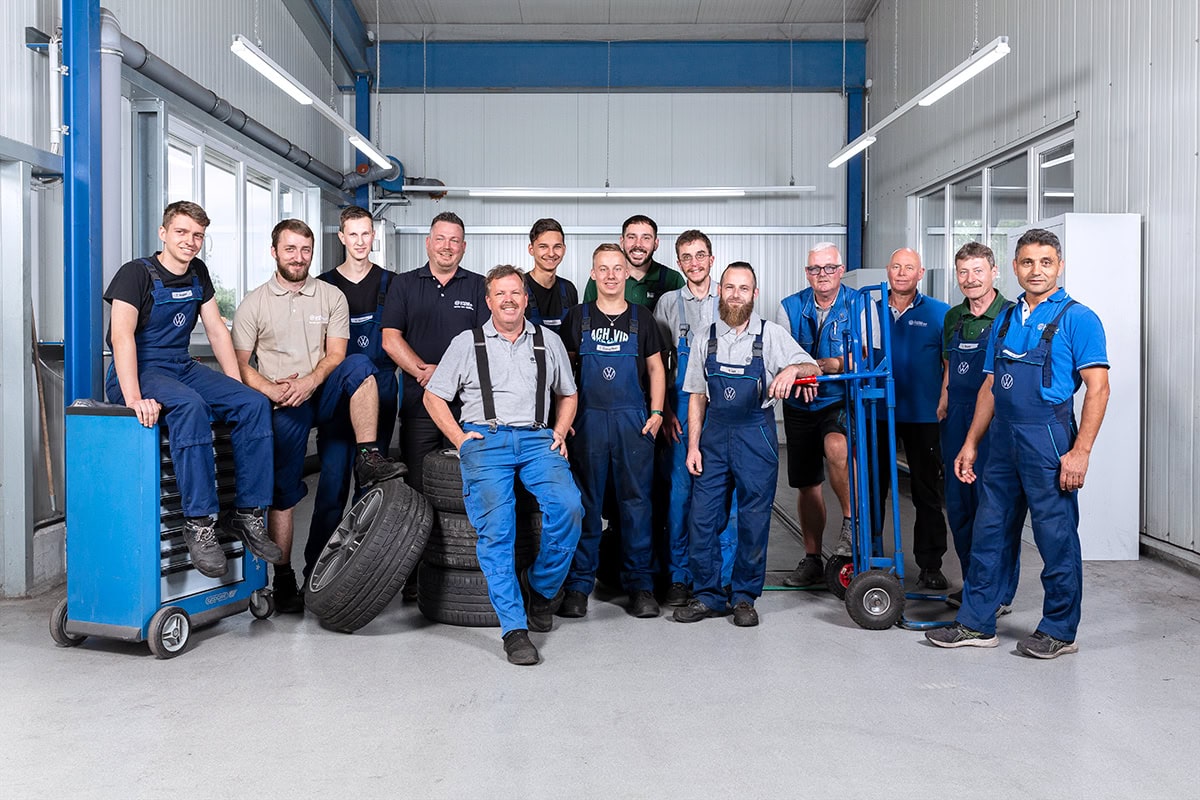 Team von Mechanikern und Technikern in Werkstatt, professionell und freundlich.