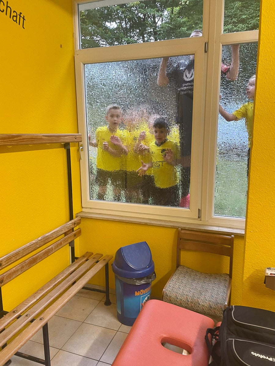 Kinder im Regen hinter Fensterscheibe, Köln, Kinderfotografie.