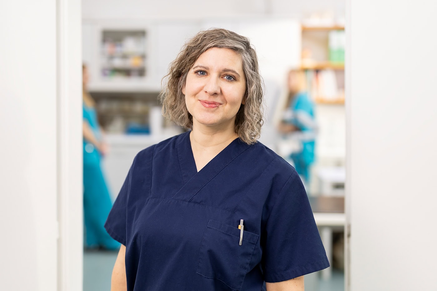 Pflegekraft in blauer Uniform in Krankenhausumgebung in Köln.
